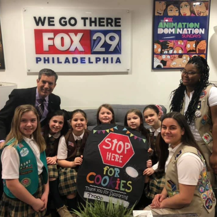FOX29 host with a troop of local Girl Scouts selling cookies